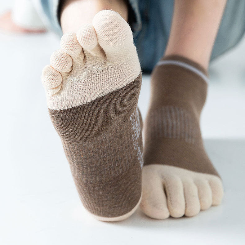 Person wearing brown five-finger socks on a white background