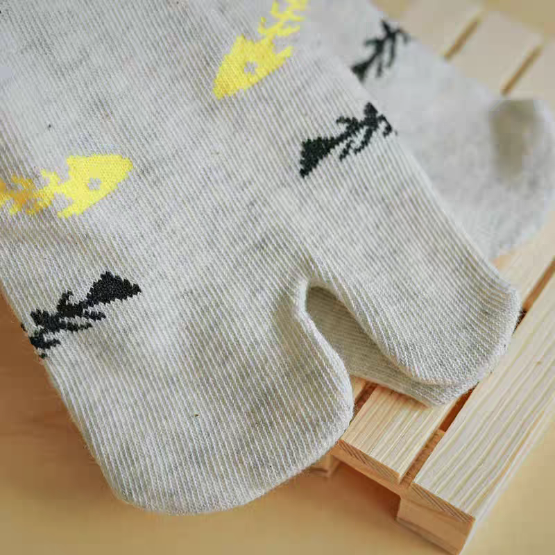 Gray socks with yellow and black designs on a wooden surface