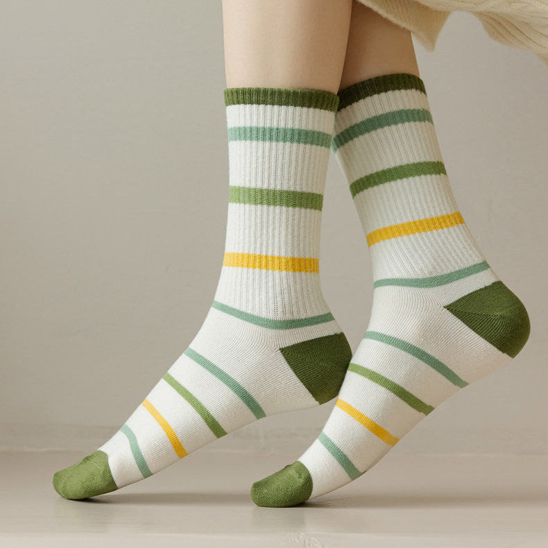 A person wearing white crew socks with green and yellow stripes