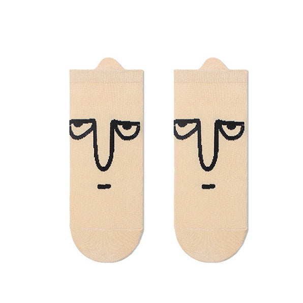 Beige socks with face design on a white background