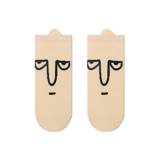 Beige socks with face design on a white background