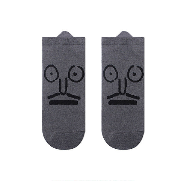 Two gray socks with black face designs on a white background