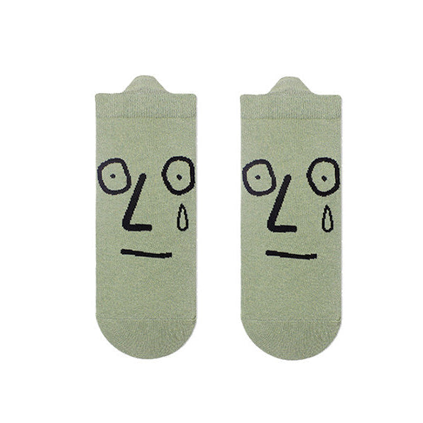 Two socks with face designs on a white background