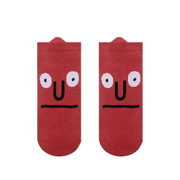 Red socks with cartoon face design on a white background