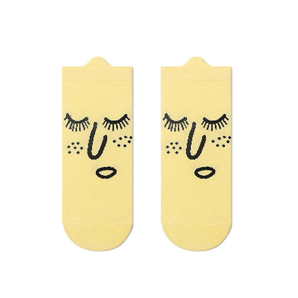 Pair of yellow socks with face design on a white background