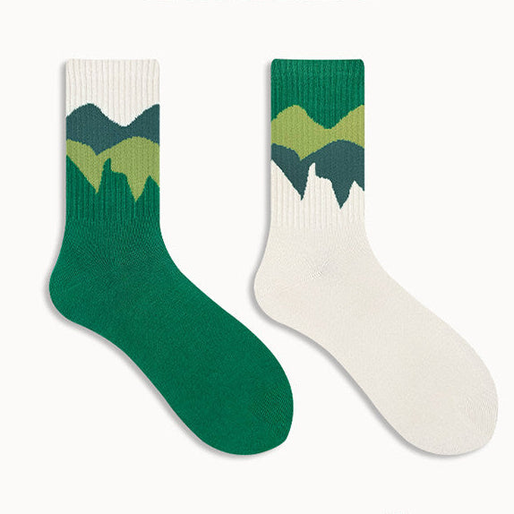 Two green and white socks with mountain design on a white background
