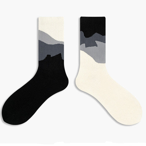 Two socks with black and white gradient design on a light gray background