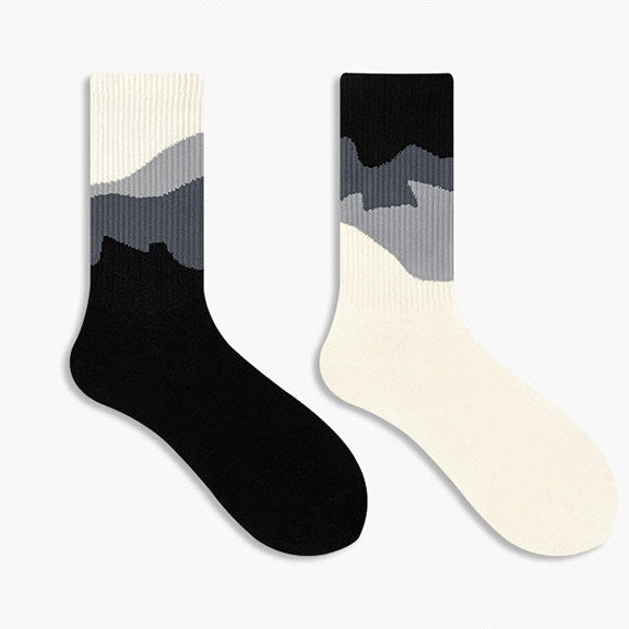 Two gradient socks in black, gray, and white on a white background 