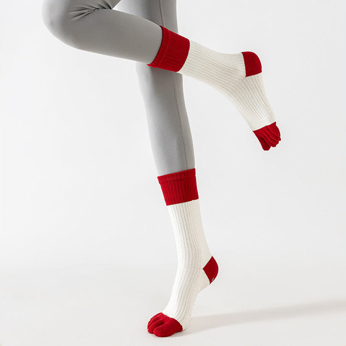 Person wearing gray leggings with red accents and white socks on a white background