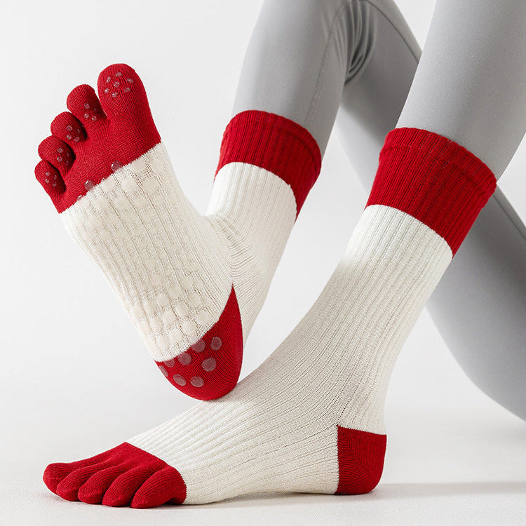 Red and white socks with toe separation design on a light gray background