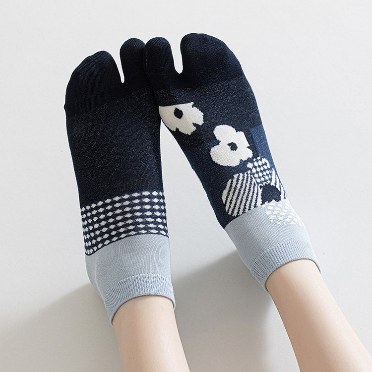 Pair of navy blue and light gray toe socks with floral design on a neutral background