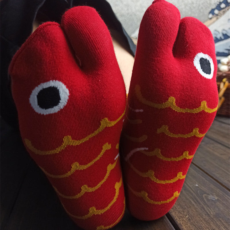 Red socks with fish patterns on a wooden floor