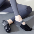 Person wearing black and gray yoga socks on a yoga mat