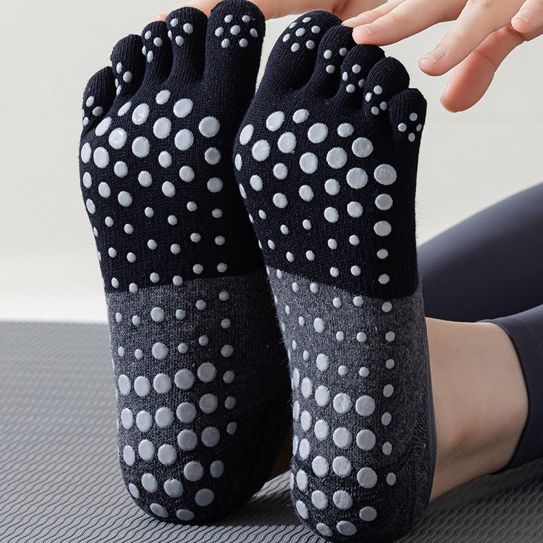 Black and gray toe-separated socks with white dots on a neutral background